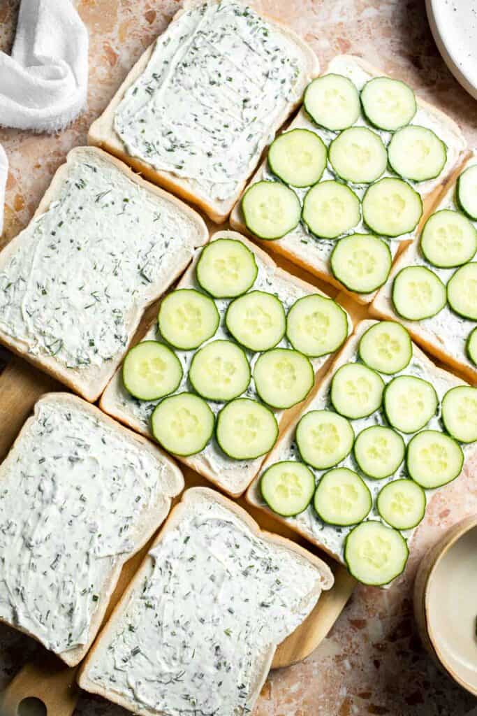 Thinly sliced English cucumber arranged over cream cheese-covered bread.