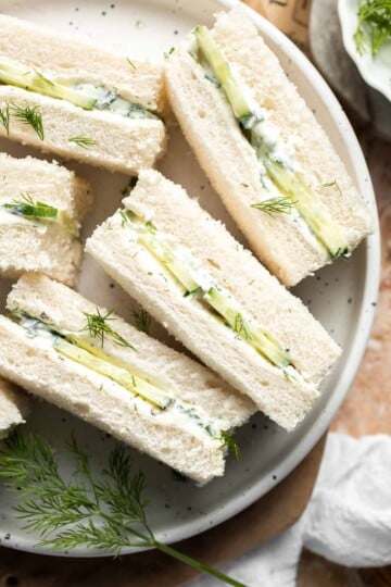 Cucumber Tea Sandwiches arranged on a serving plate with creamy herb filling, thinly sliced English cucumber, and fresh dill.
