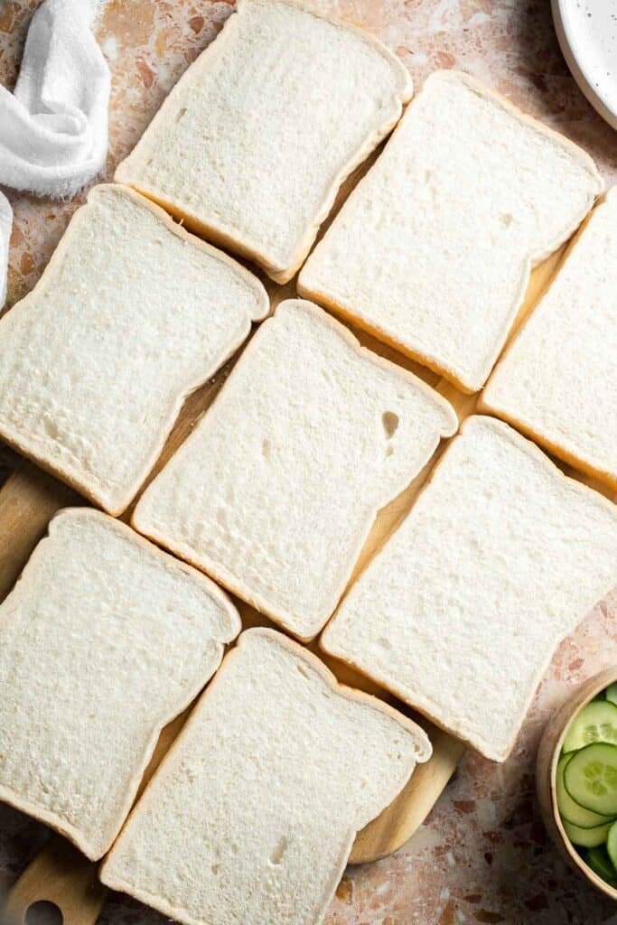 Slices of soft white sandwich bread arranged on a work surface.