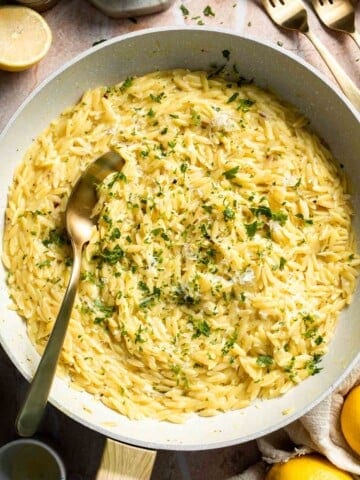 Creamy Lemon Orzo made with Parmesan cheese, fresh lemon, garlic, and parsley in a skillet.