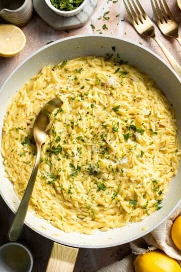 Creamy Lemon Orzo made with Parmesan cheese, fresh lemon, garlic, and parsley in a skillet.