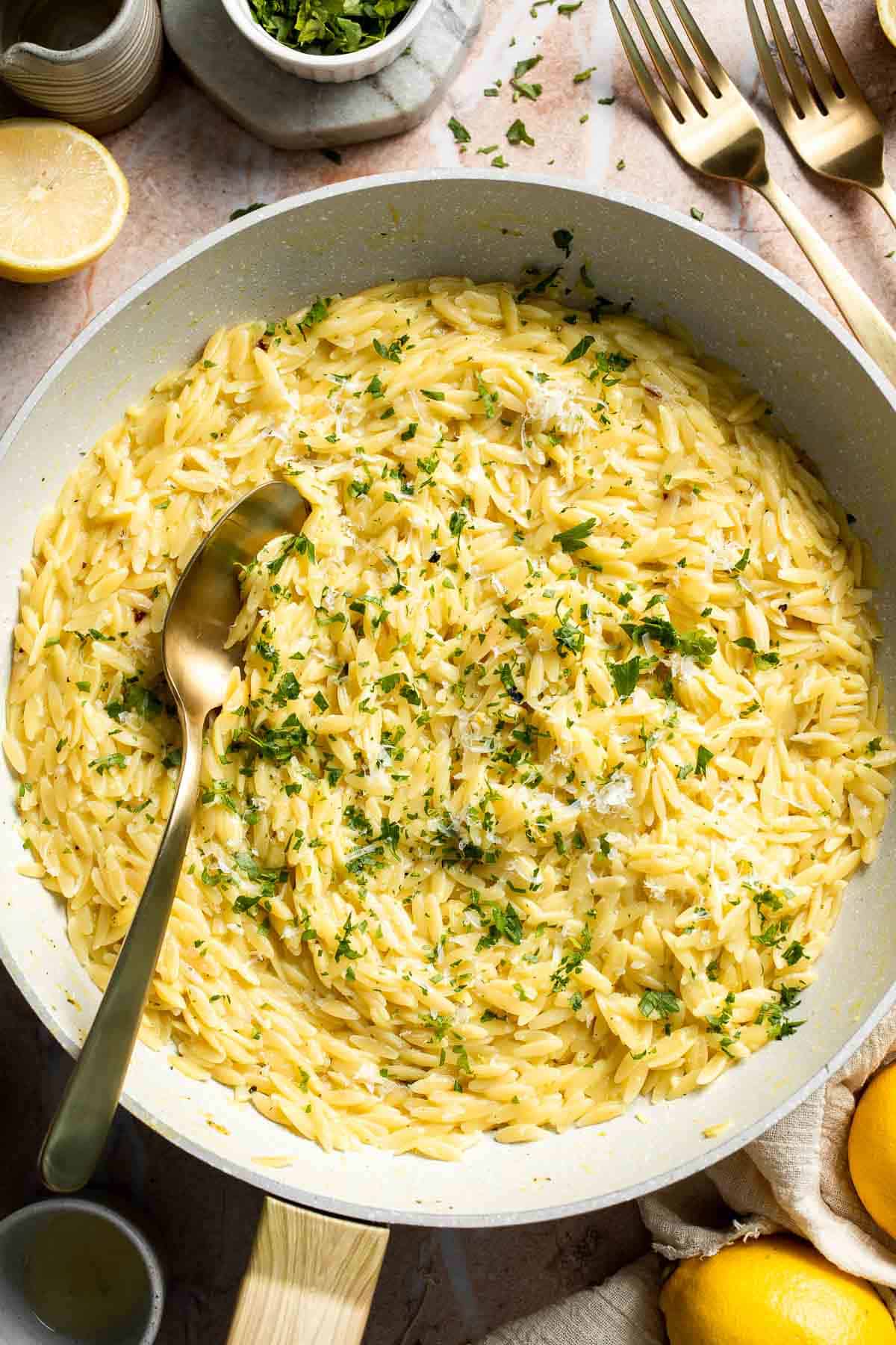 Creamy Lemon Orzo made with Parmesan cheese, fresh lemon, garlic, and parsley in a skillet.