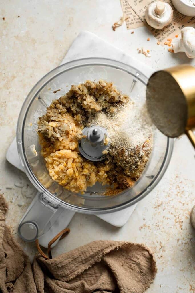 Adding breadcrumbs to the lentil patty mixture.