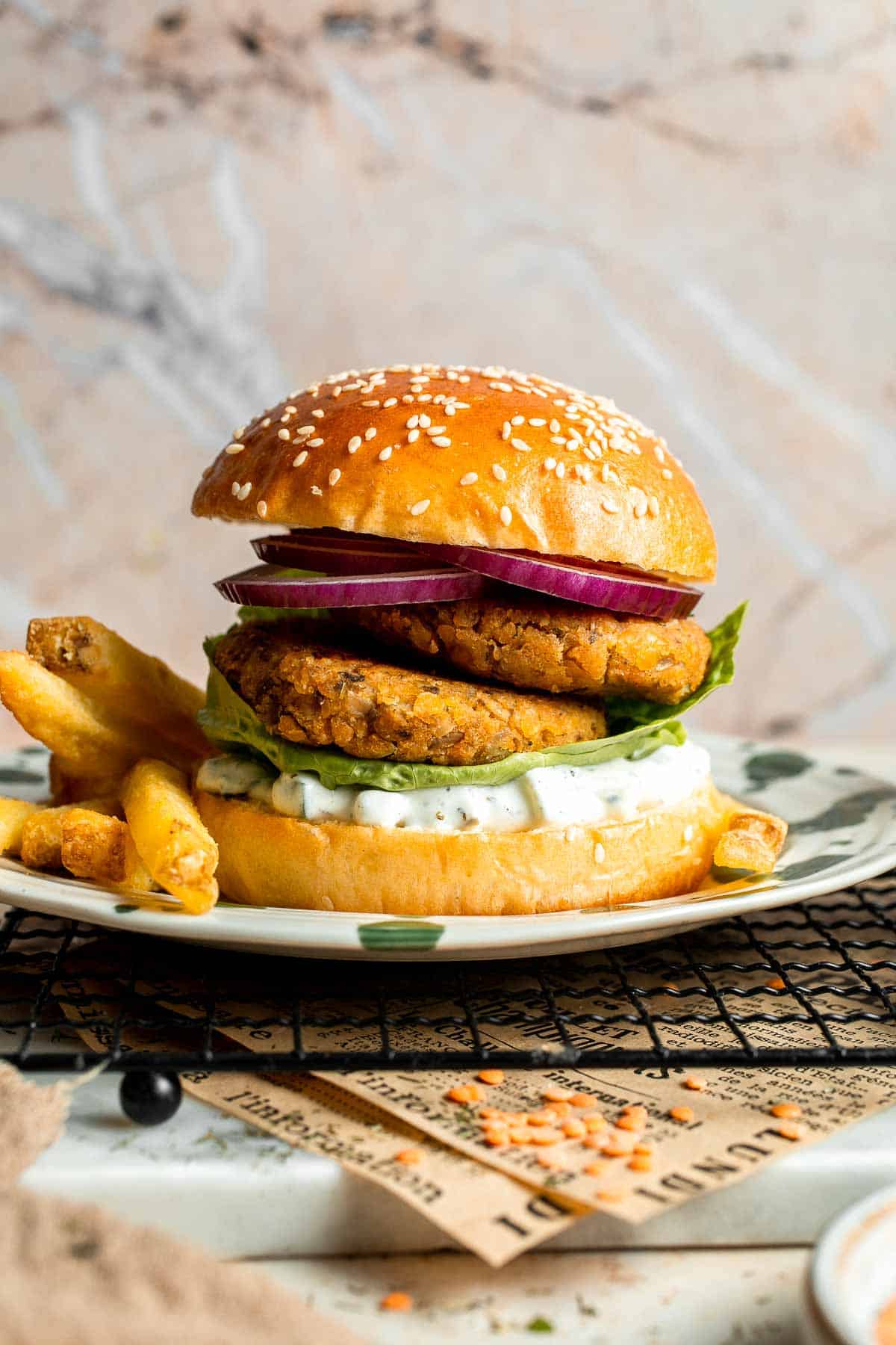 Crispy lentil patties served as a vegetarian burger with lettuce and sauce.