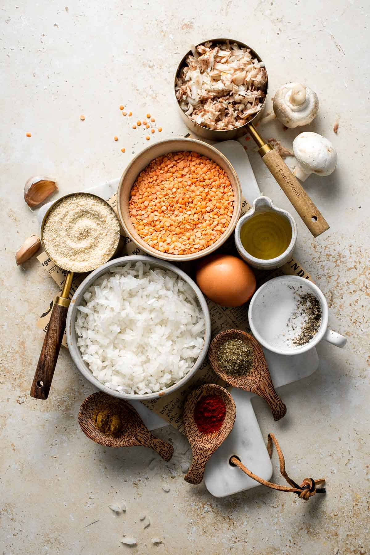 Ingredients for crispy lentil patties including red lentils, mushrooms, onion, garlic, breadcrumbs, egg, and spices.