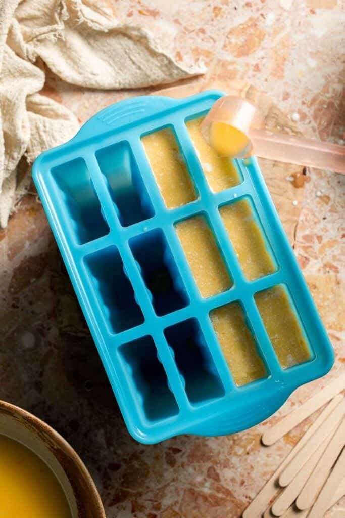 Adding the orange layer to homemade Orange Creamsicles.