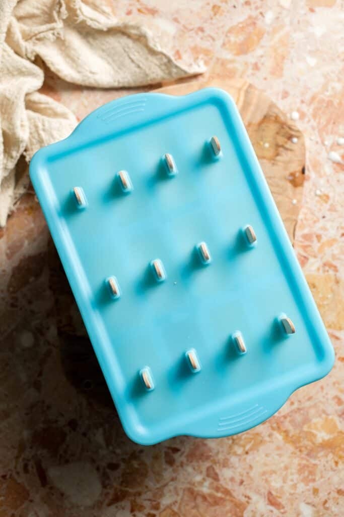 Orange Creamsicles in a covered popsicle mold ready to freeze.