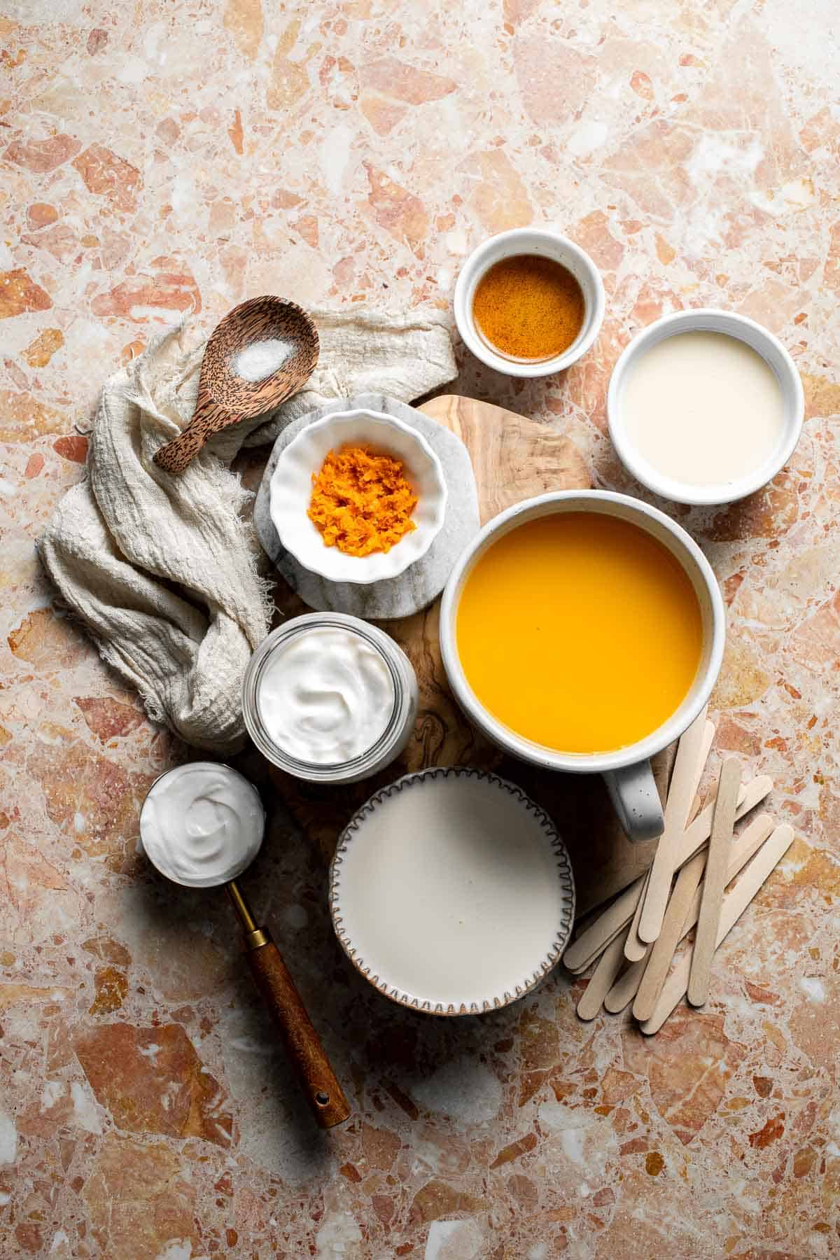 Ingredients for homemade Orange Creamsicles including orange juice, Greek yogurt, heavy cream, sweetened condensed milk, and vanilla.