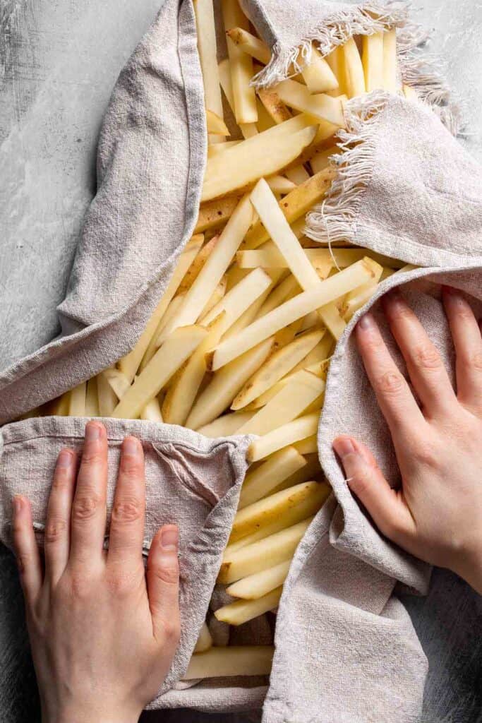 Drying cut potatoes thoroughly before baking.