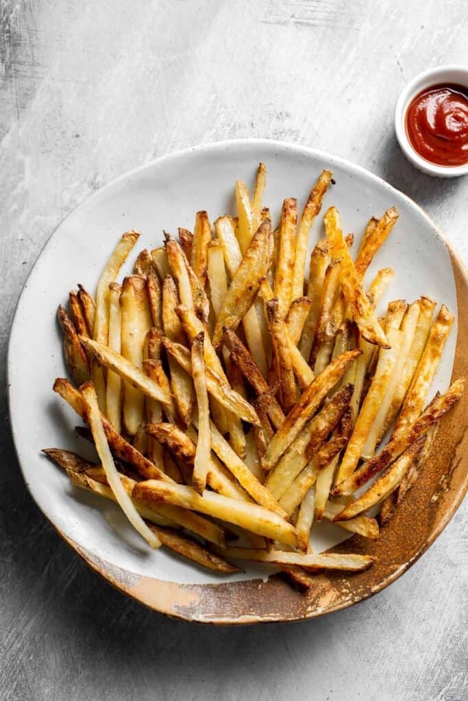 Homemade French fries served with ketchup.