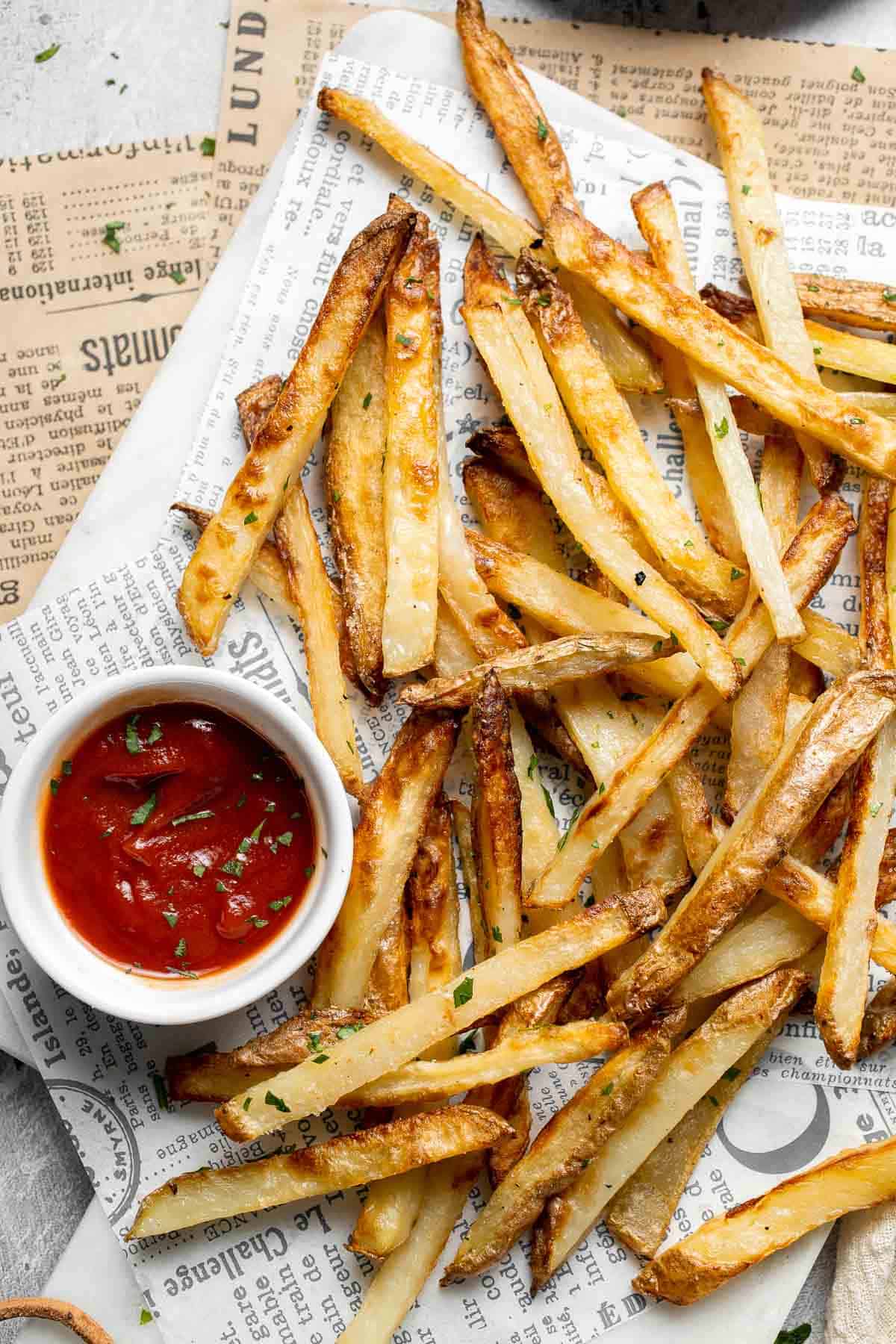Crispy homemade French fries served with ketchup on a platter.