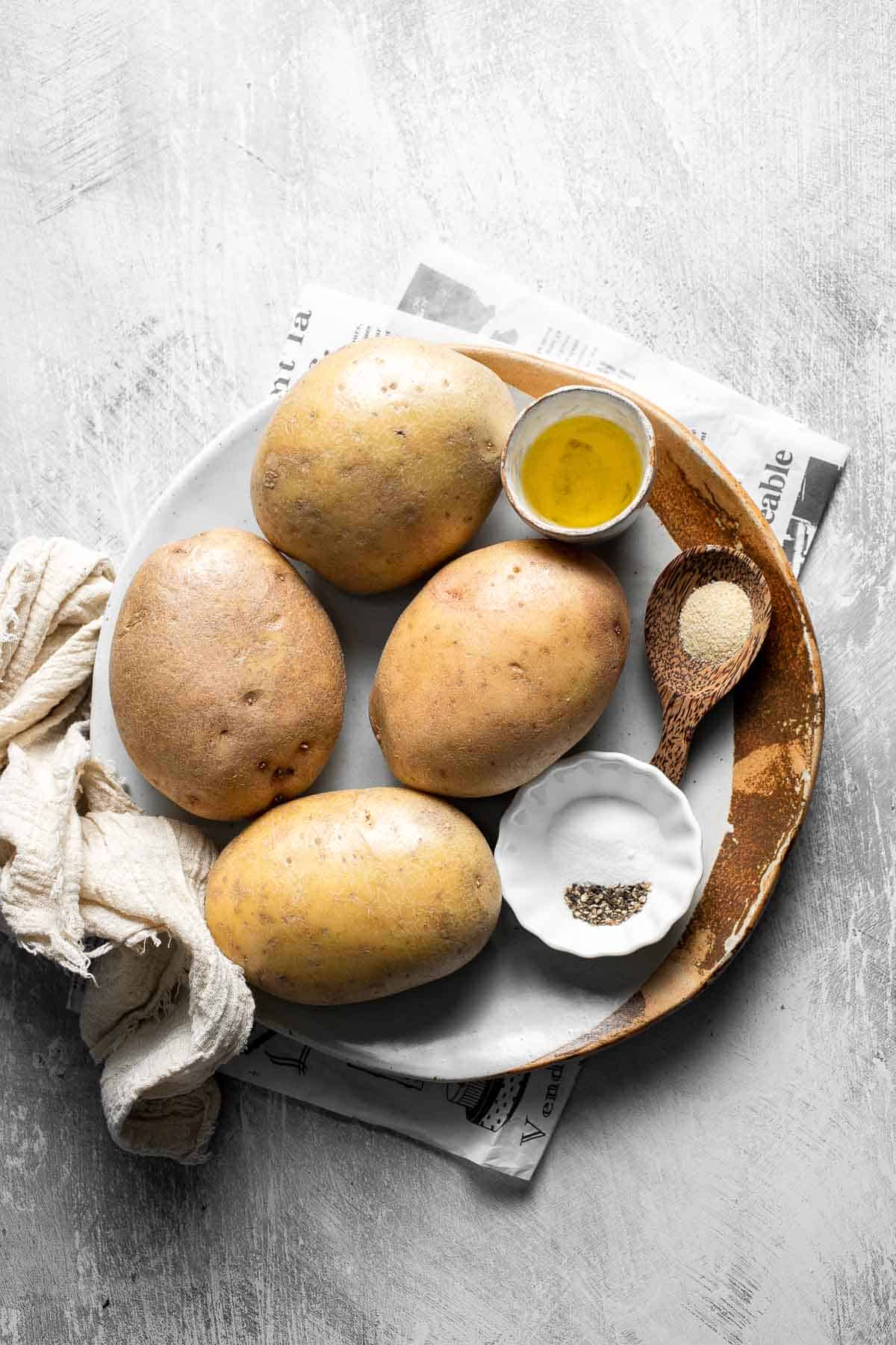 Ingredients for Oven Baked French Fries including russet potatoes, olive oil, salt, garlic powder, and black pepper.