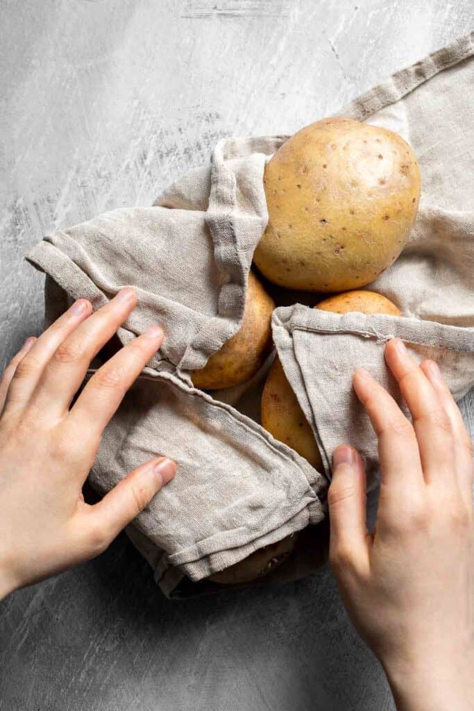 Drying russet potatoes before cutting them into homemade French fries.