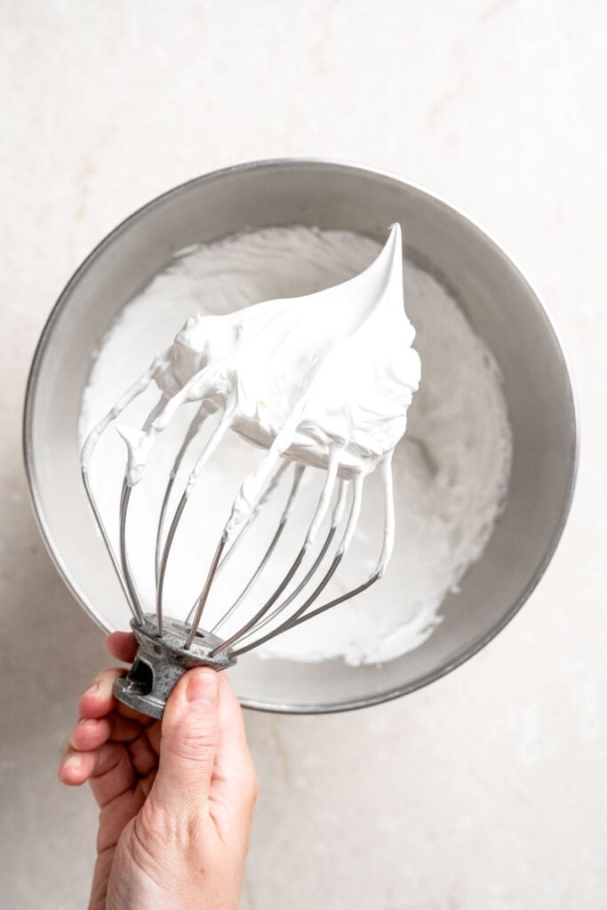 Homemade marshmallow topping with stiff peaks on a whisk attachment.