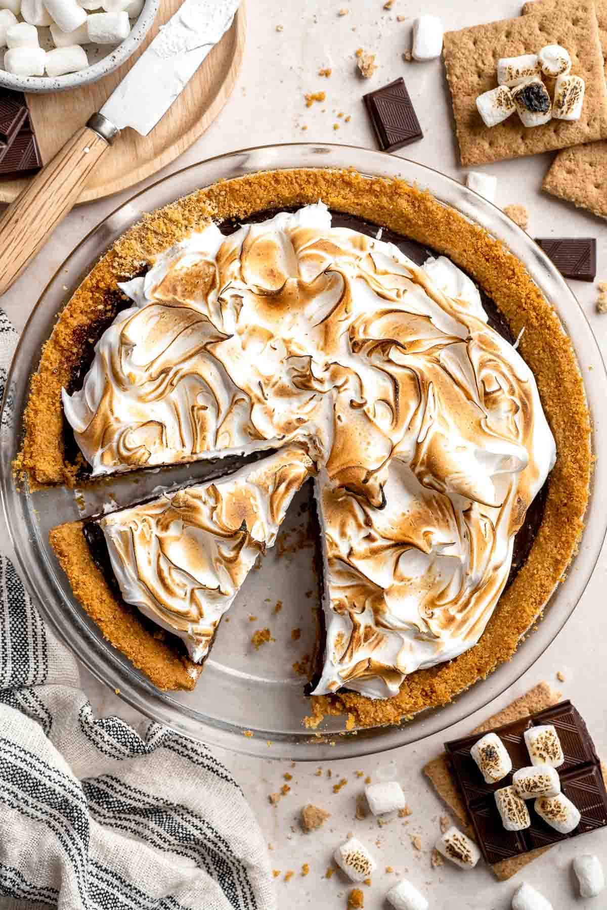 S'mores Pie with a slice removed to reveal the chocolate ganache filling and graham cracker crust.