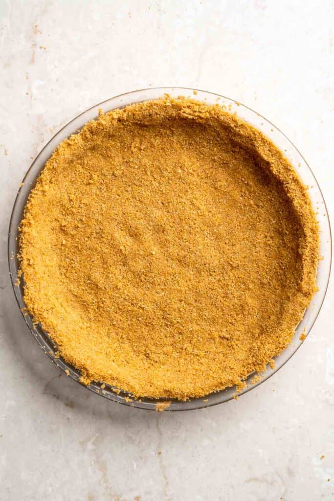 Baked graham cracker crust in a pie dish, cooled and ready for the chocolate filling.