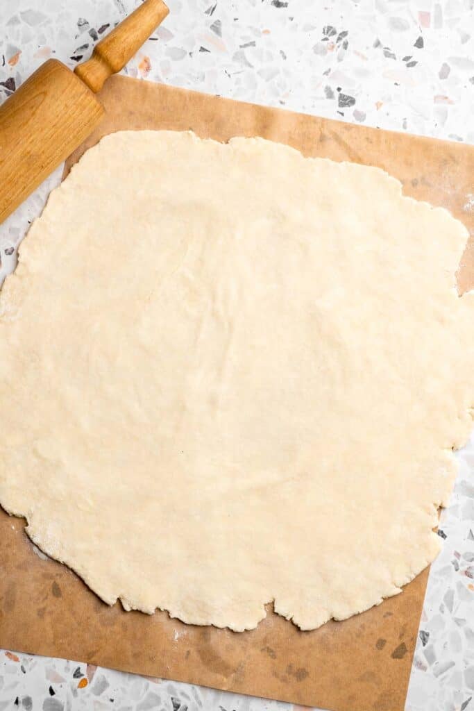 Pie dough rolled out into a thin, even round on parchment paper