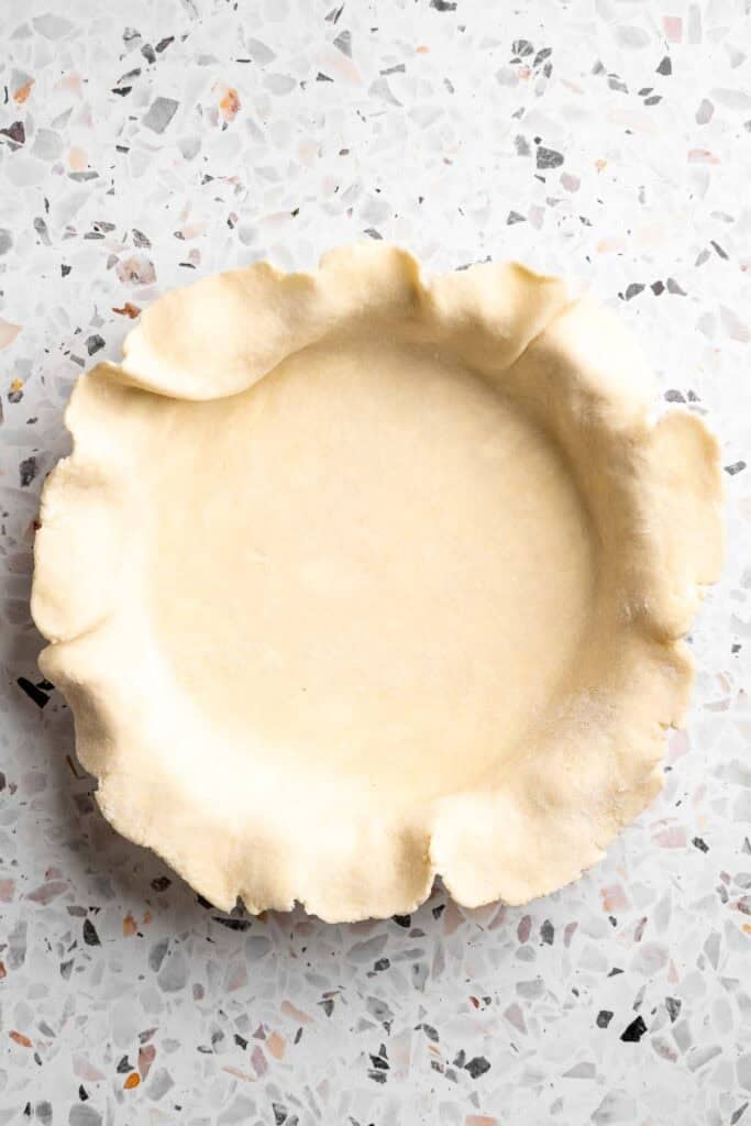 Rolled pie dough pressed into a pie dish