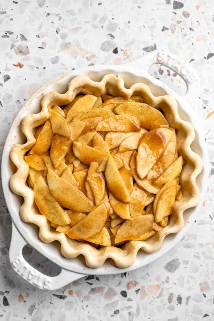 Spiced apple filling arranged in an unbaked pie crust