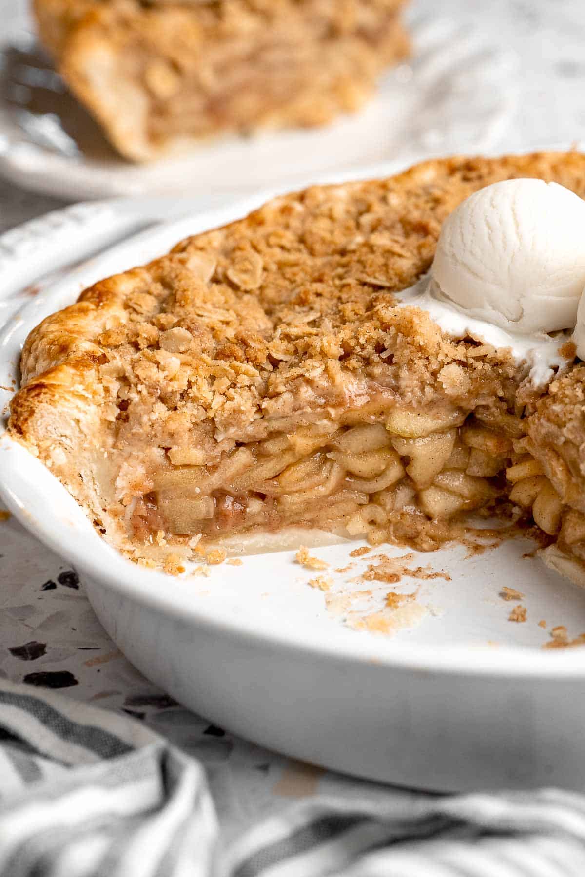 Apple crumble pie with a slice removed, showing the apple filling inside