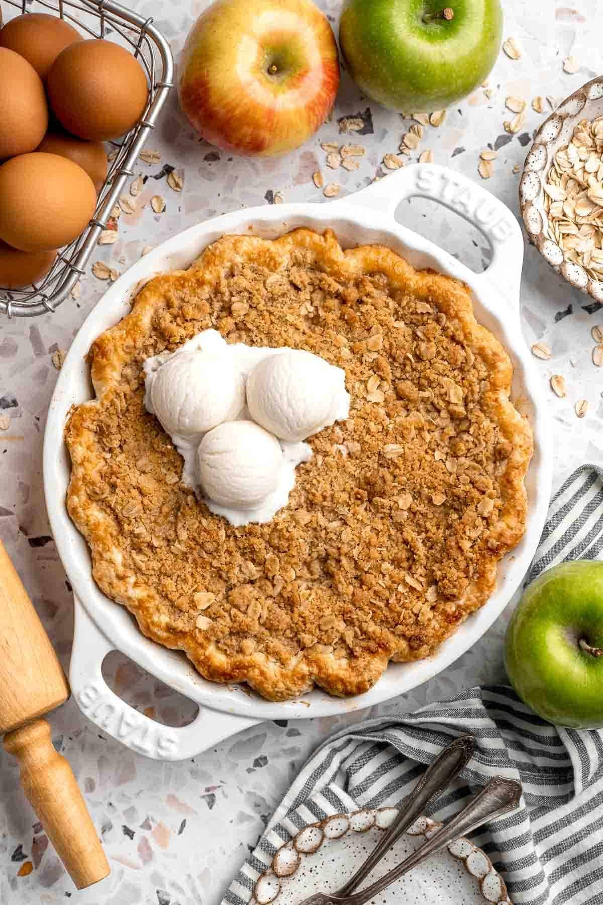Baked apple crumble pie with a golden, crisp crumble topping topped with vanilla ice cream
