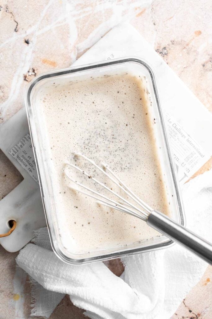 Whisked chia pudding mixture in a glass container before chilling
