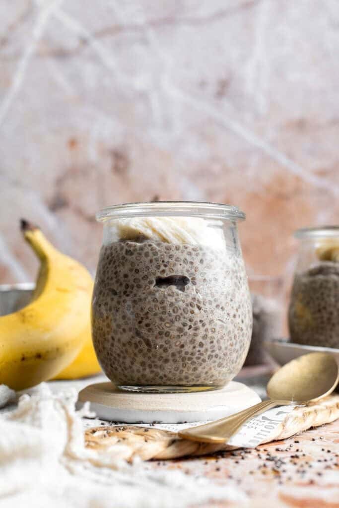 Banana chia pudding divided into an individual jar for serving and topped with banana slices