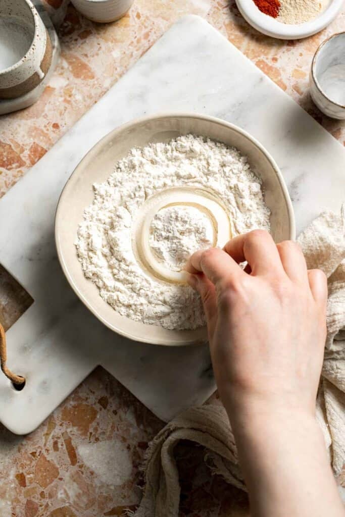 Dredging onion rings in flour.