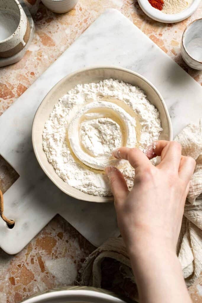 Shaking excess flour from onion rings.