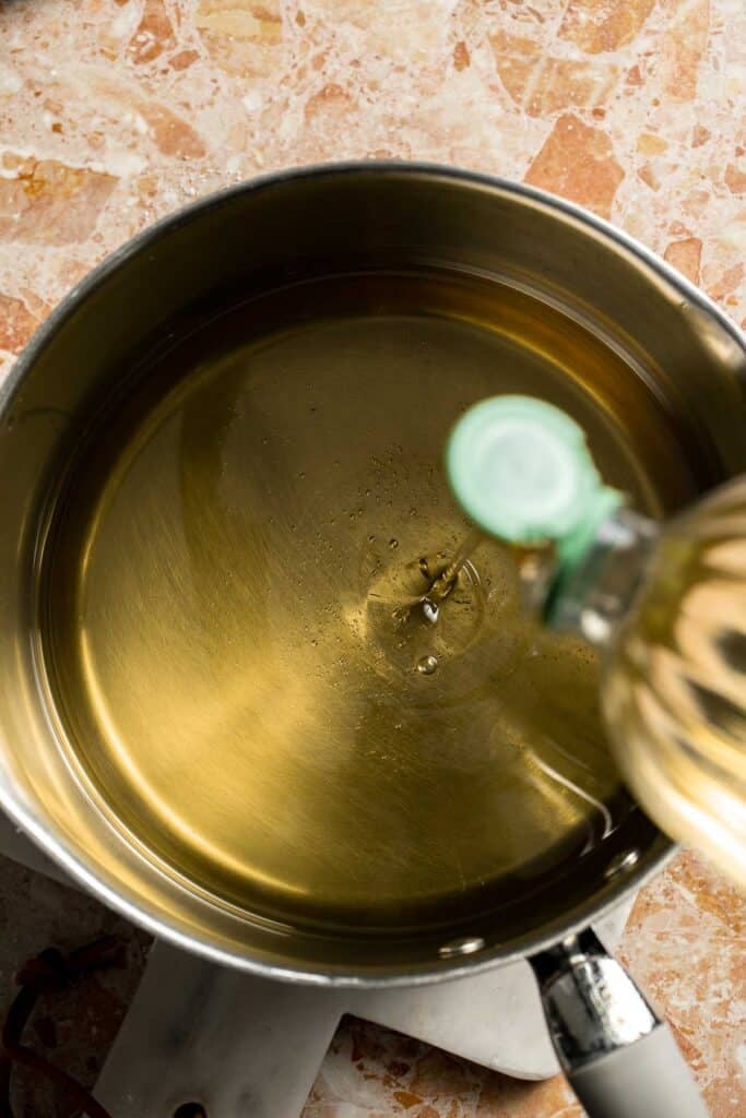 Pouring vegetable oil into a Dutch oven.