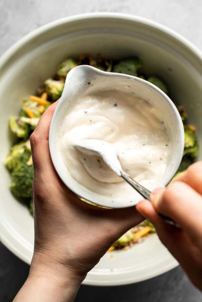 Mixing the creamy broccoli salad dressing until smooth.