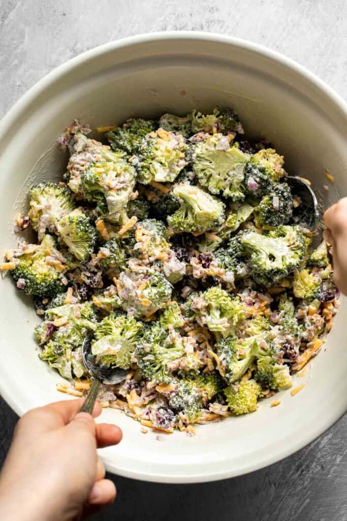 Giving the broccoli salad a final toss before serving.