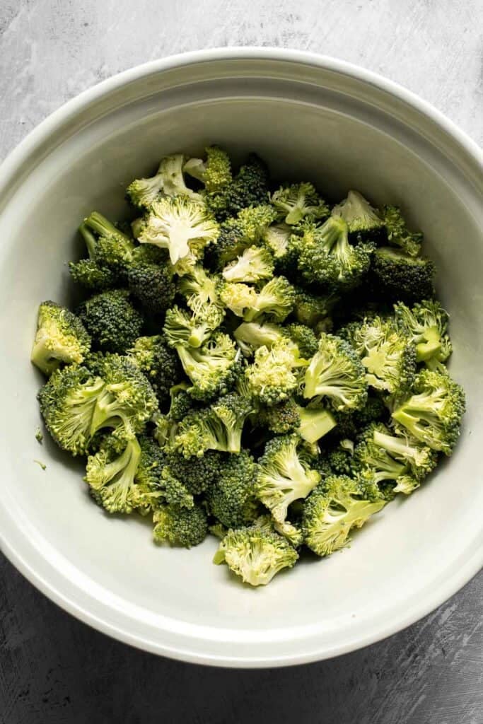 Broccoli florets in a large mixing bowl.
