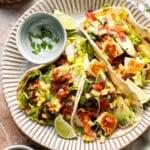Halloumi Tacos with crispy halloumi, fresh mango salsa, creamy avocado, and crunchy cabbage served with lime wedges.