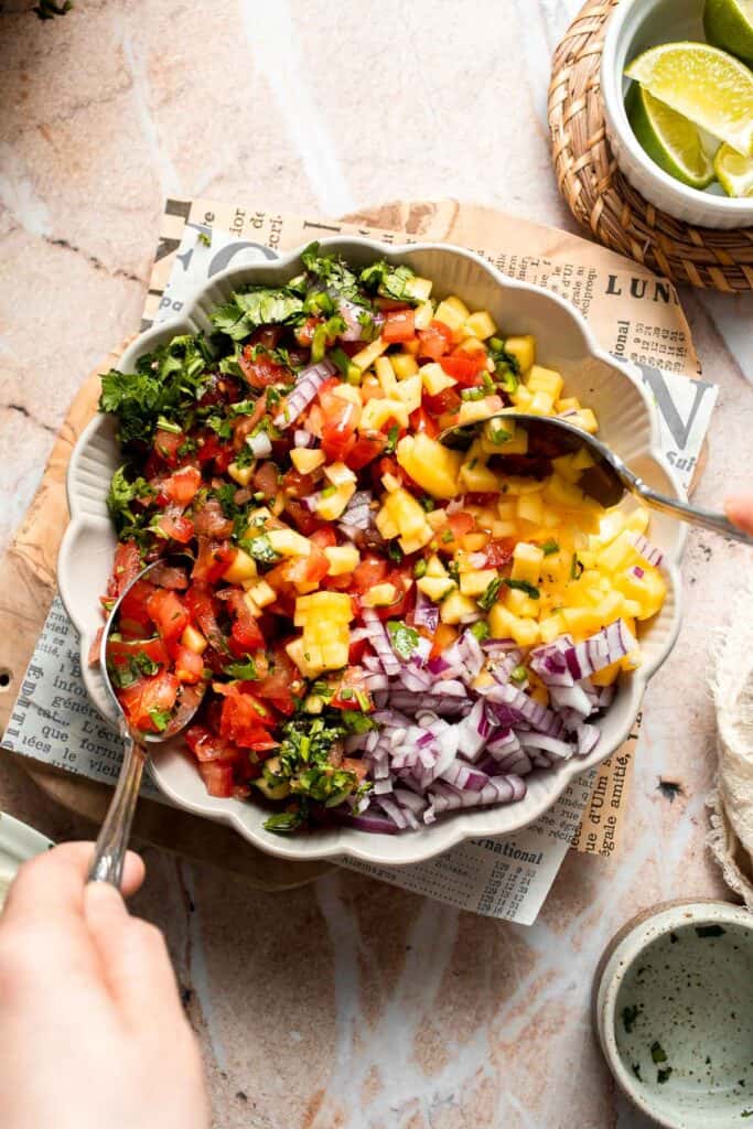 Mixing the fresh mango salsa together.