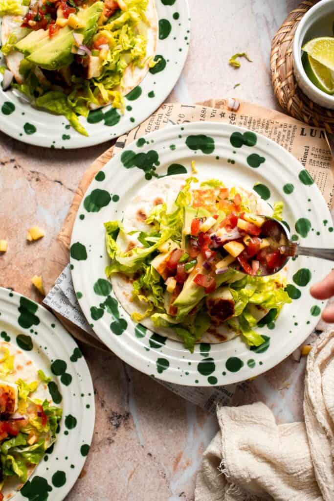 Topping the taco with fresh mango salsa.