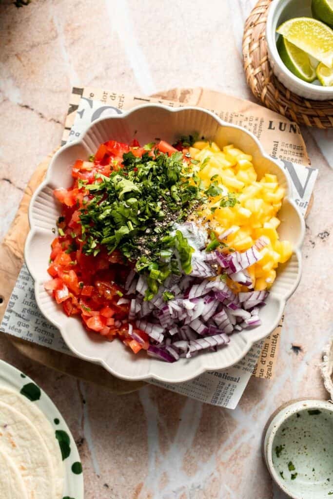 Ingredients for fresh mango salsa in a mixing bowl.