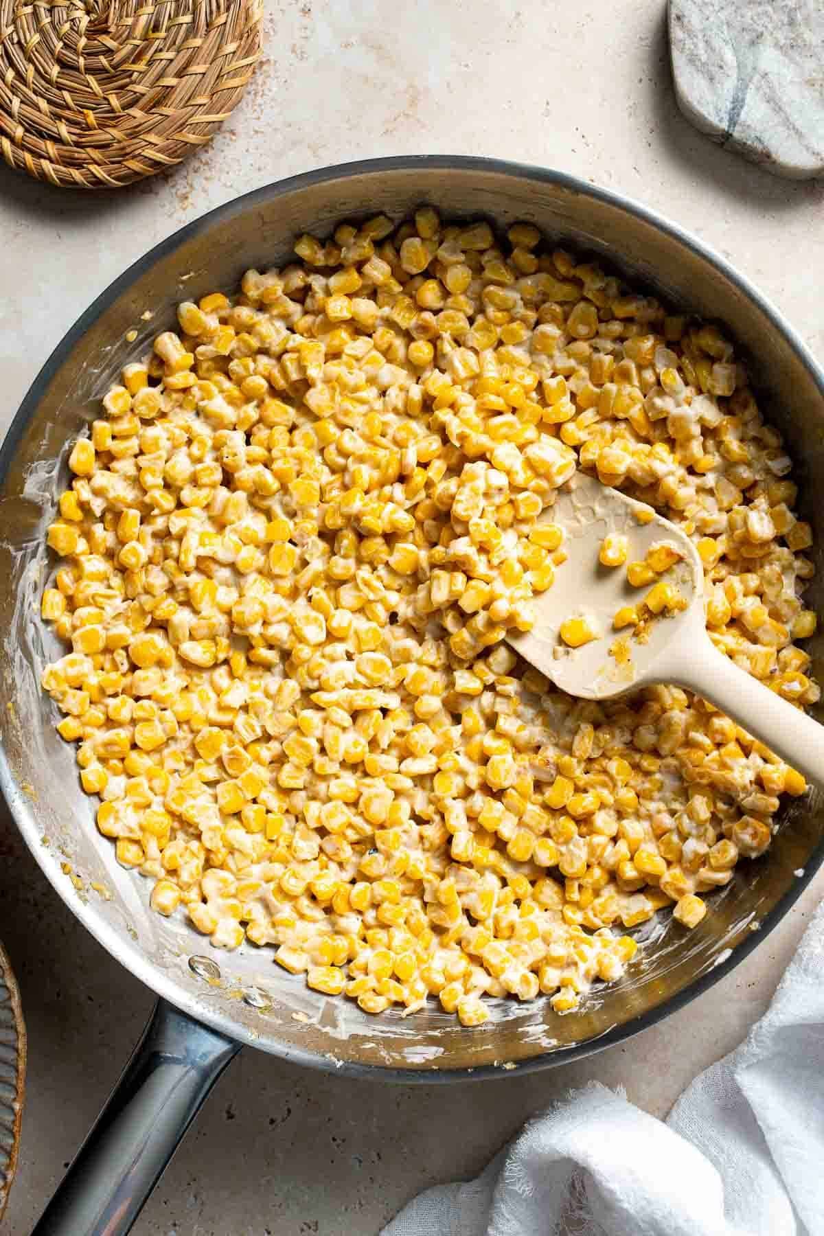 Corn coated in a smooth, creamy honey butter sauce in a skillet