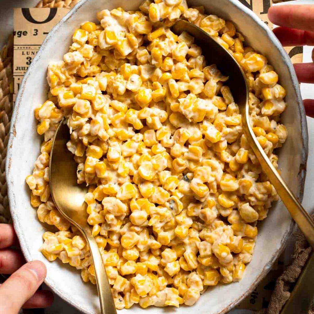 Overhead view of honey butter skillet corn in a serving bowl with a spoon