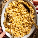 Overhead view of honey butter skillet corn in a serving bowl with a spoon