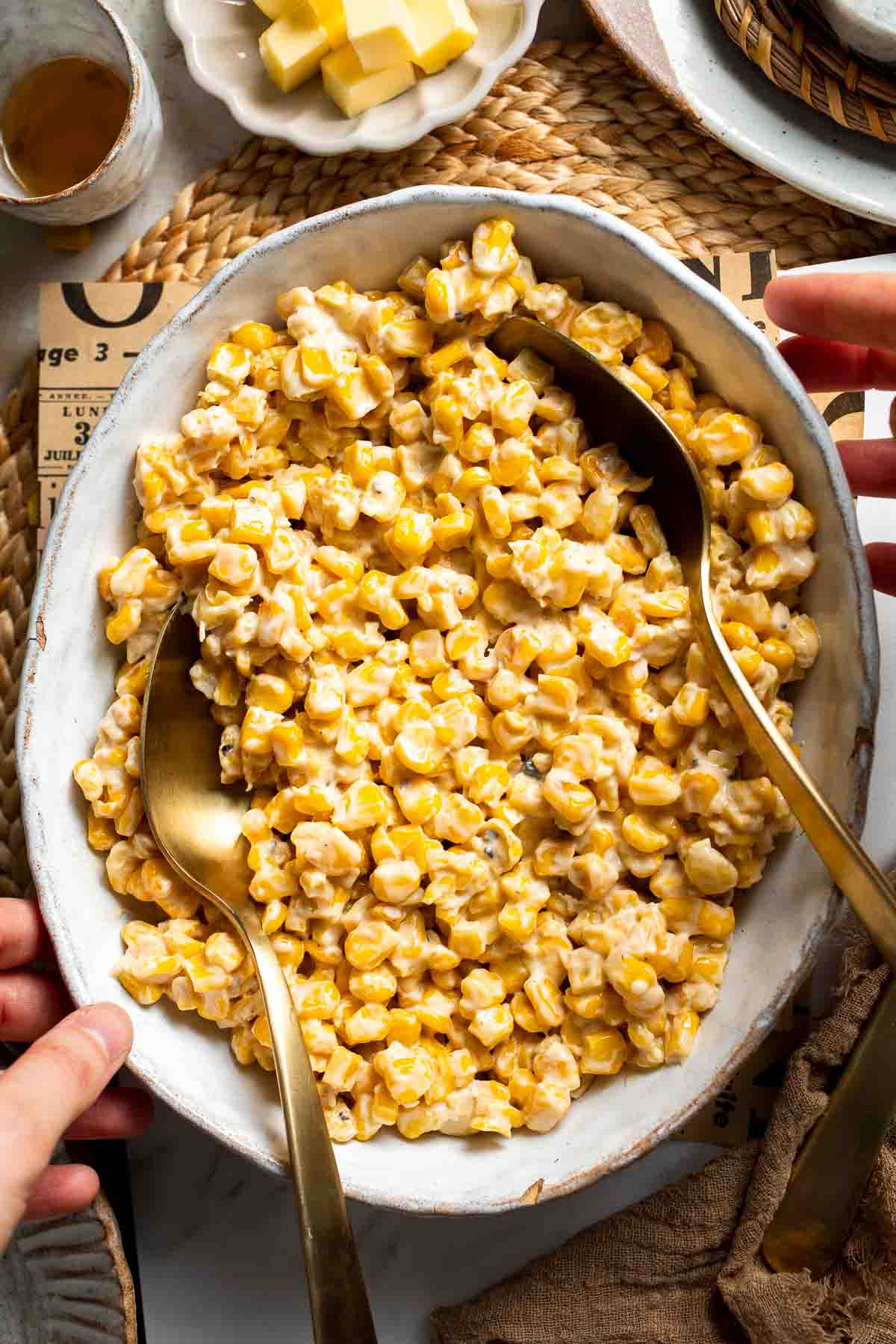 Overhead view of honey butter skillet corn in a serving bowl with a spoon