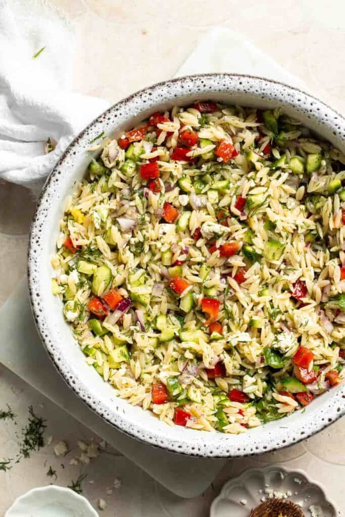 Finished Lemon Orzo Salad with fresh vegetables, feta, dill, and lemon dressing.