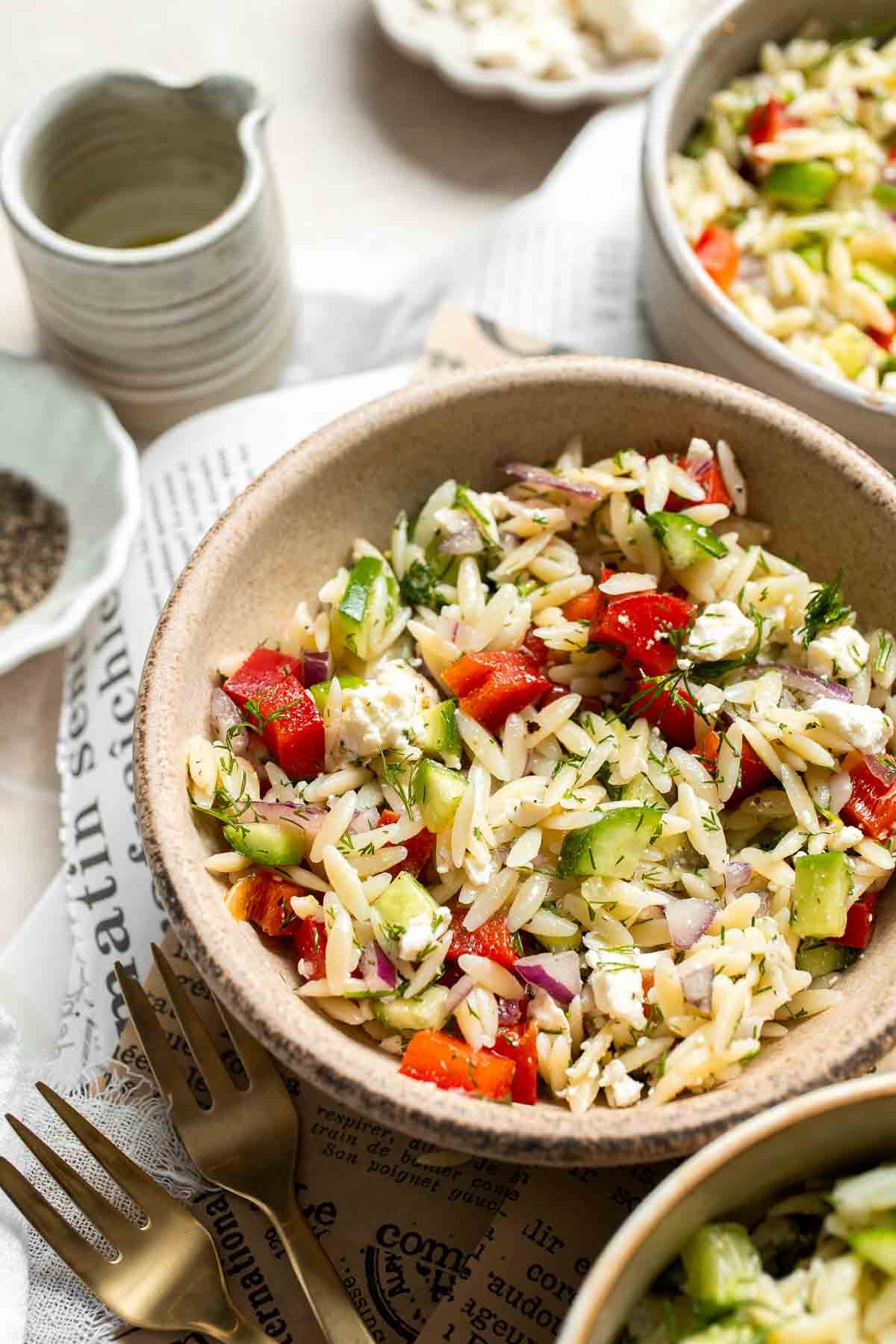 Bowl of Lemon Orzo Salad with colorful vegetables, feta cheese, and fresh dill.