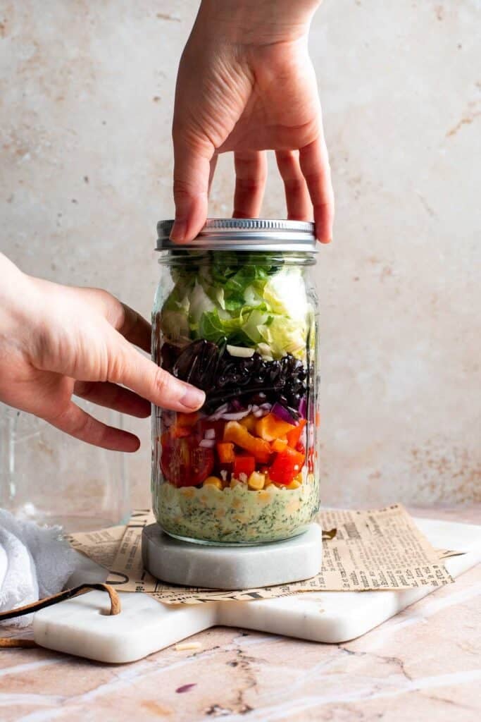 Closing the lid of the assembled Southwest mason jar salad