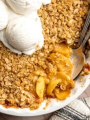 Warm Peach Crisp with juicy baked peaches, a buttery oat topping, and vanilla ice cream.