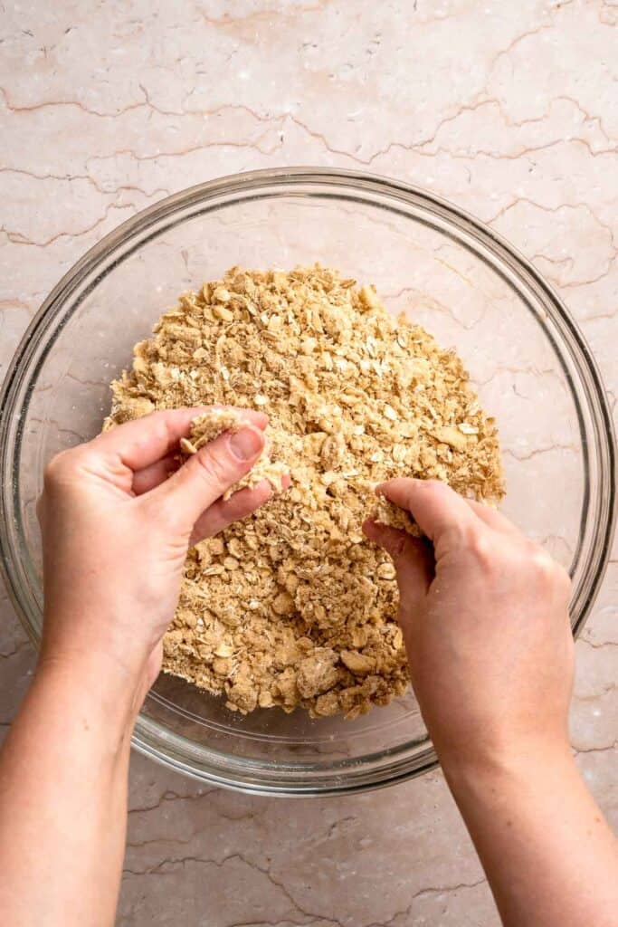 Cutting cold butter into the crisp topping mixture until crumbly.