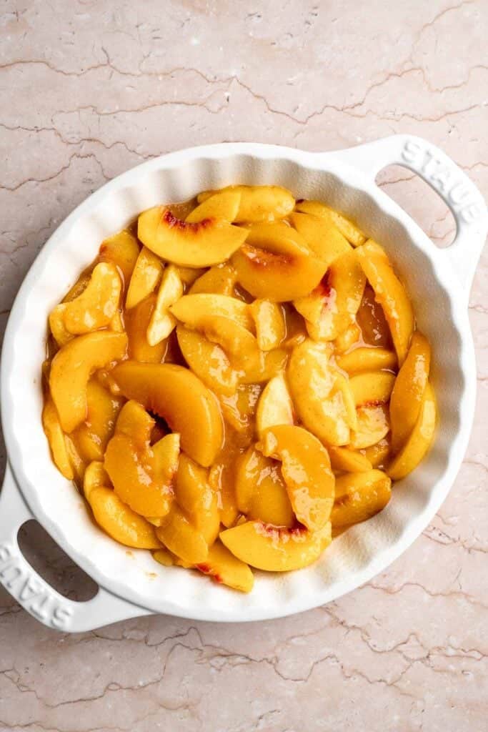 Peach filling spread evenly in a baking dish.