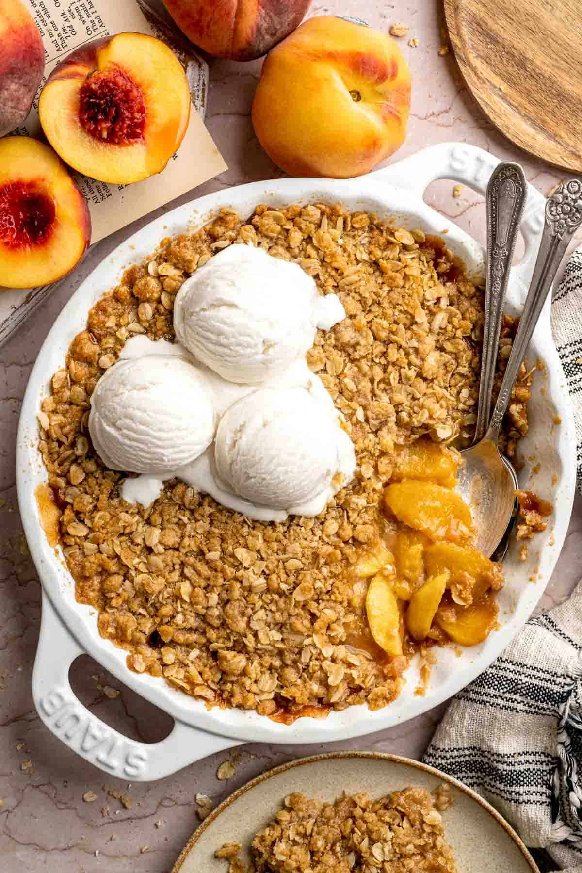 Scooping warm Peach Crisp with vanilla ice cream.