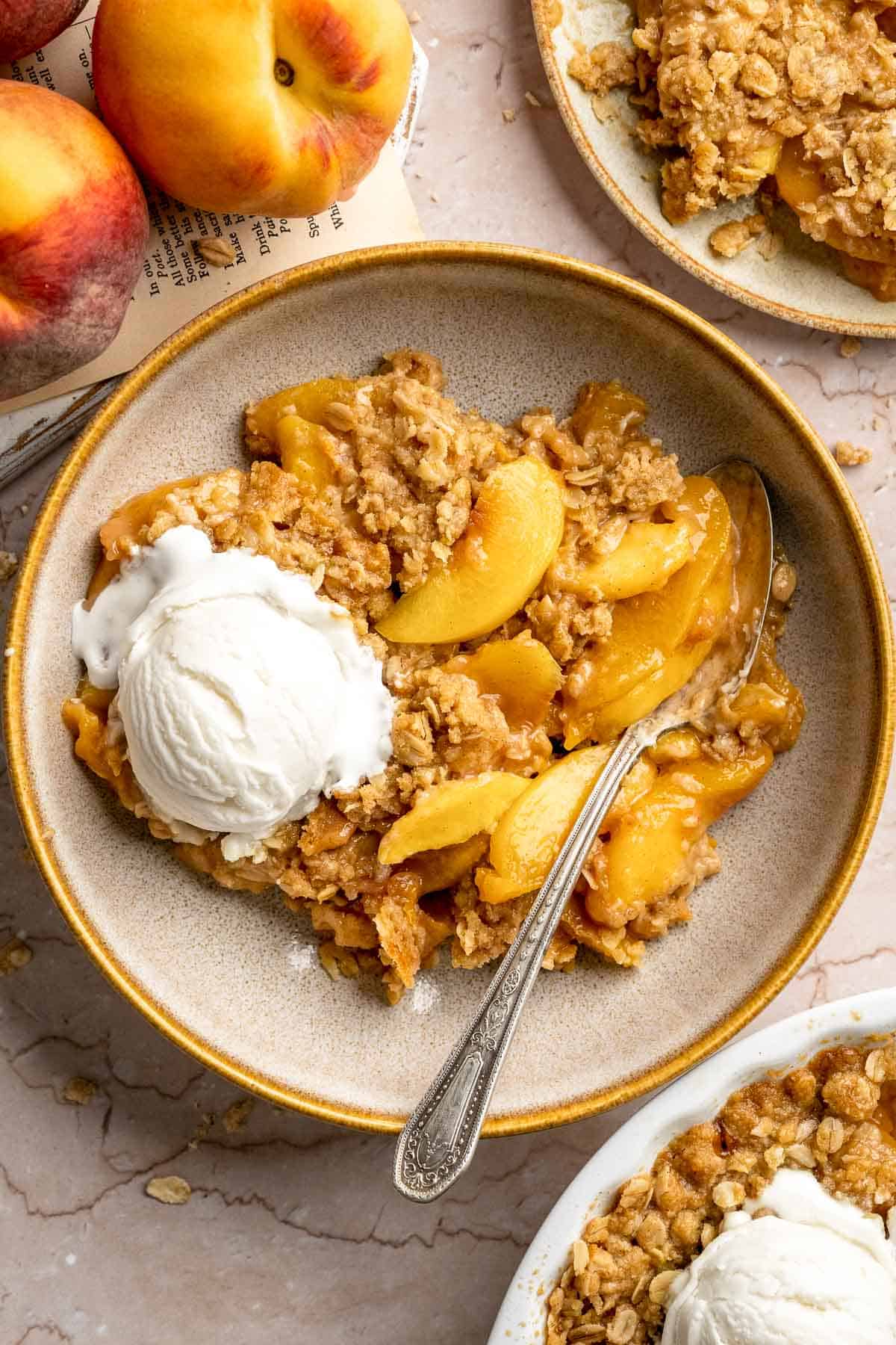 Peach Crisp served warm with vanilla ice cream on a dessert plate.