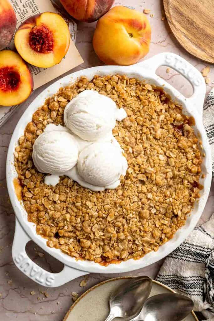Peach Crisp served warm with scoops of vanilla ice cream.